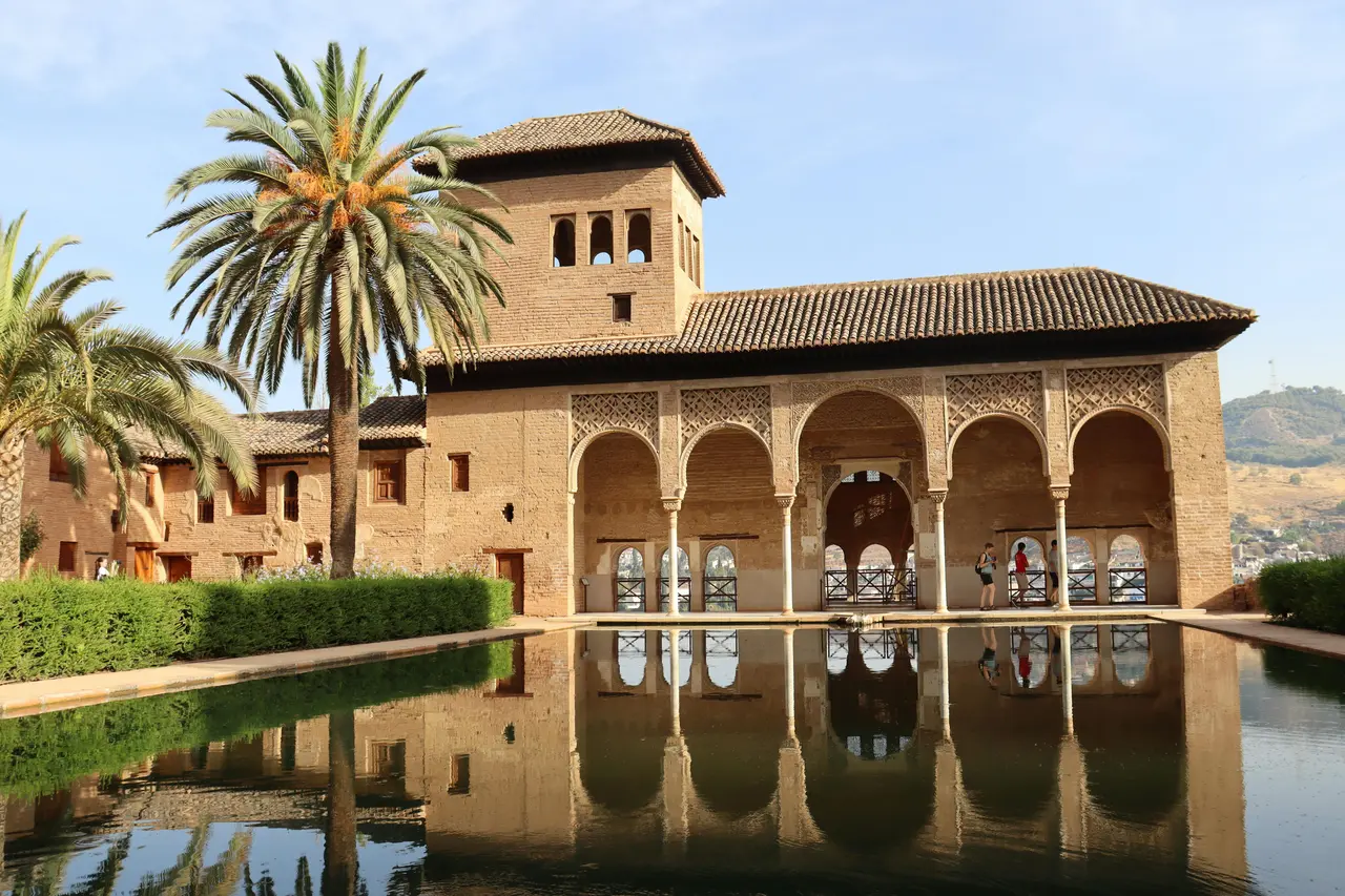 Patio de los Arrayanes en la Alhambra de Granada reflejado en el agua al atardecer