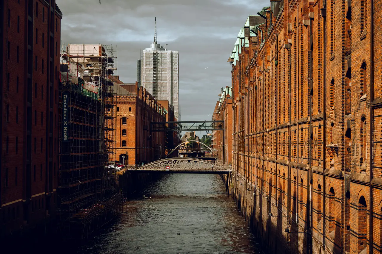 Vista panorámica del canal de la Speicherstadt de Hamburgo con almacenes de ladrillo rojo reflejándose en el agua