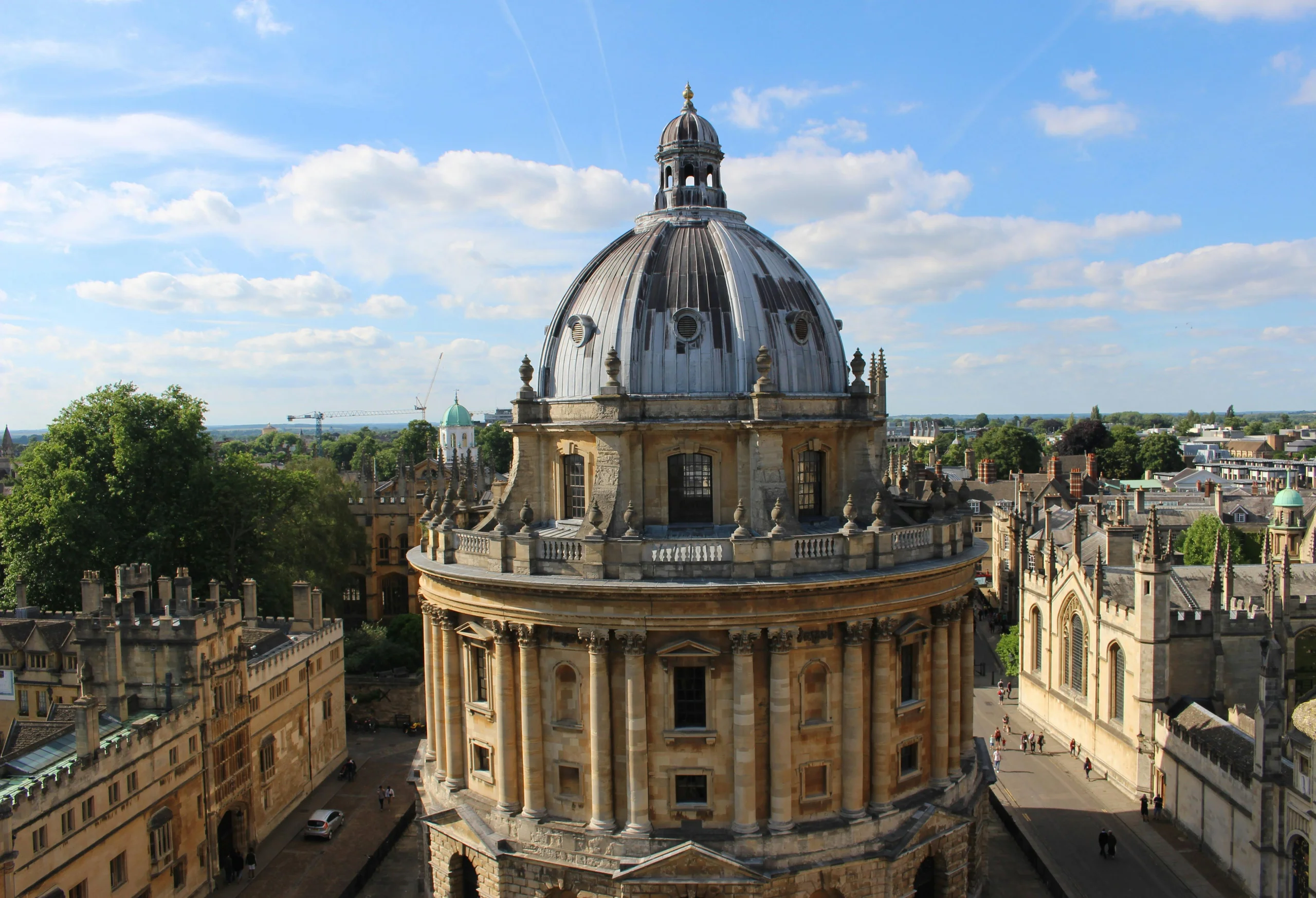 Vista aerea de la Radcliffe Camera en Oxford, banada por la luz del sol, rodeada de los colleges historicos de la universidad