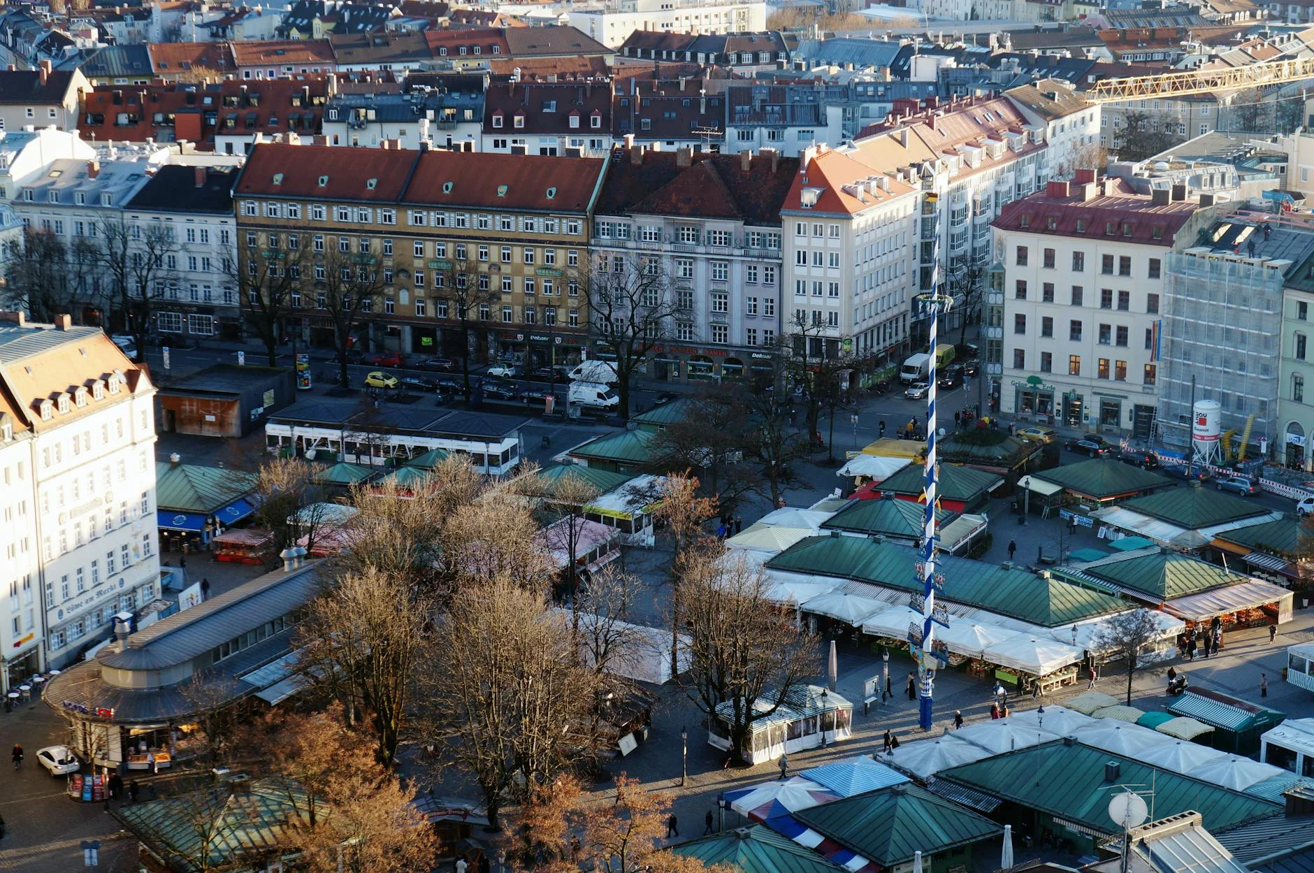 El Viktualienmarkt de Munich con puestos de comida y la torre de la iglesia al fondo