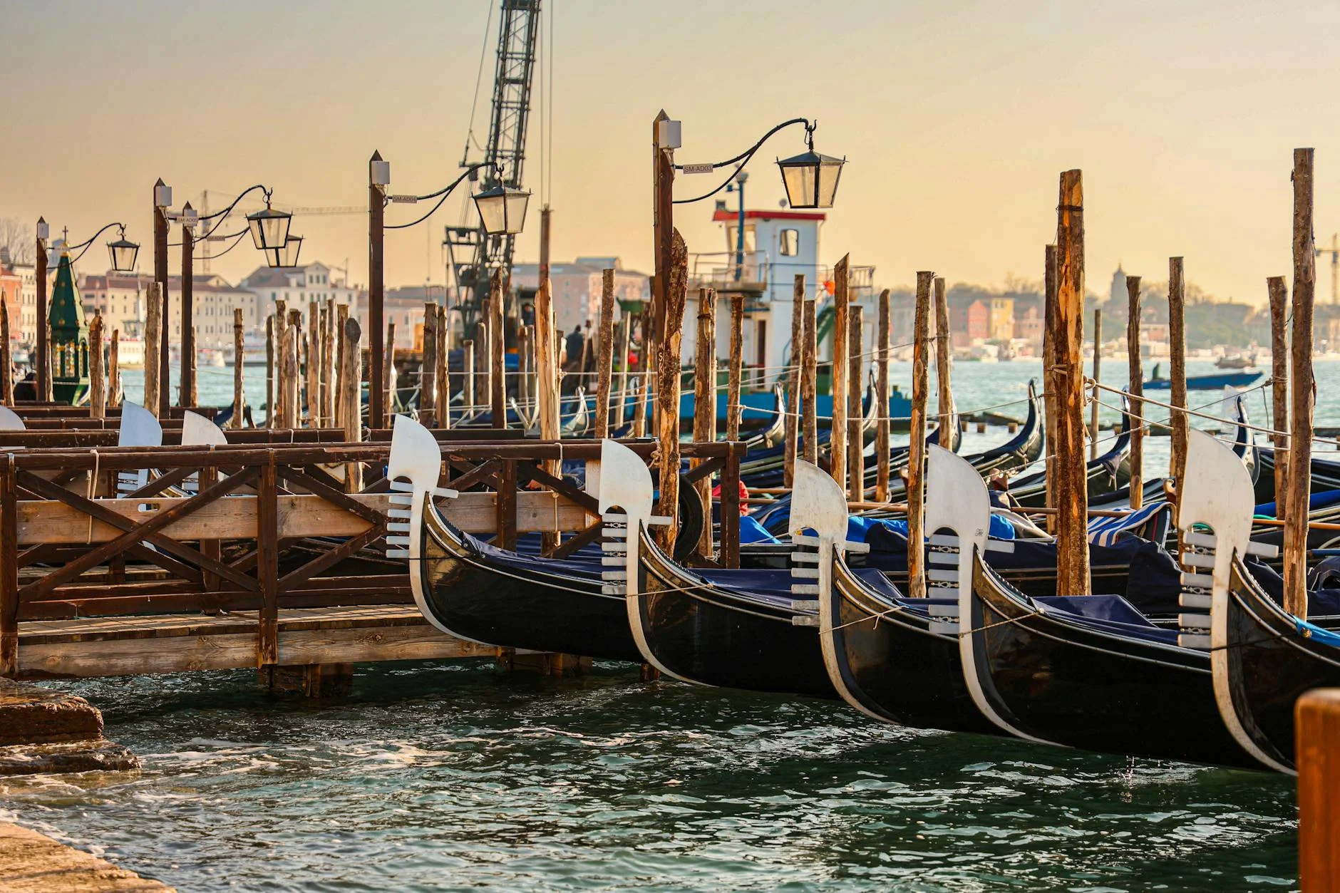 Góndolas amarradas al amanecer en un canal de Venecia, sin turistas, reflejando la calma de la ciudad temprana